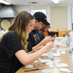 Students glazing tiles Students gazing their handmade tiles.