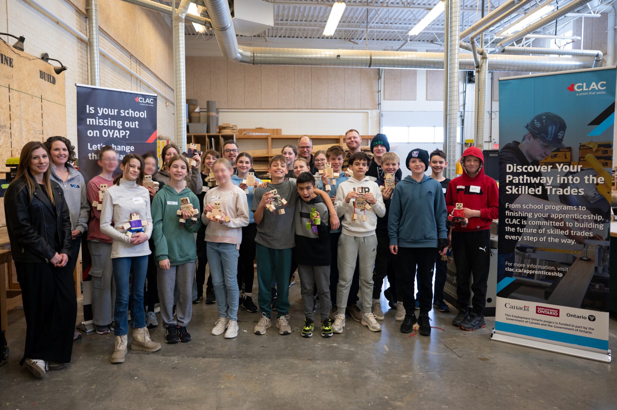 Class of students in the LCH wood shop showing off what they have made