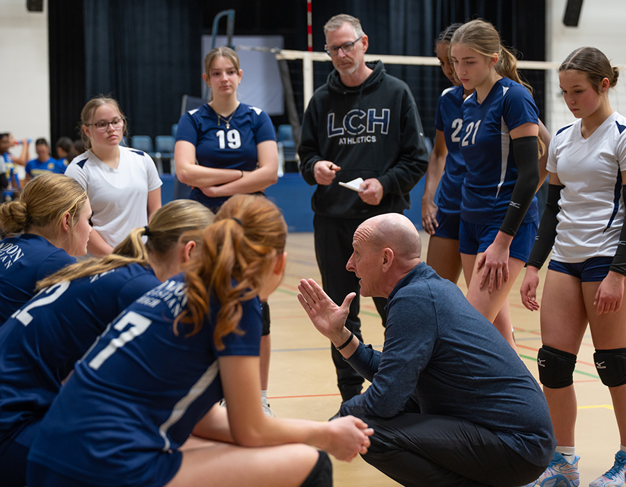 coach talking to student volleyball team
