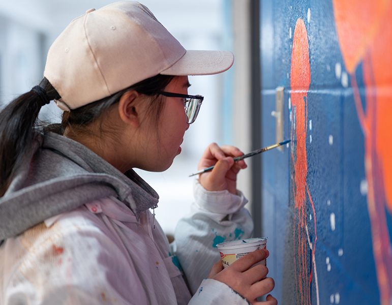 student painting mural