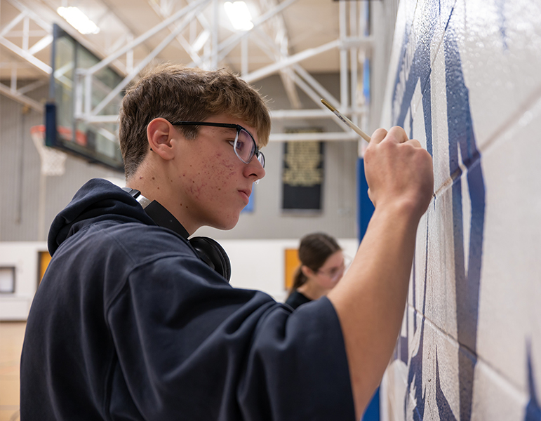 Student working on mural