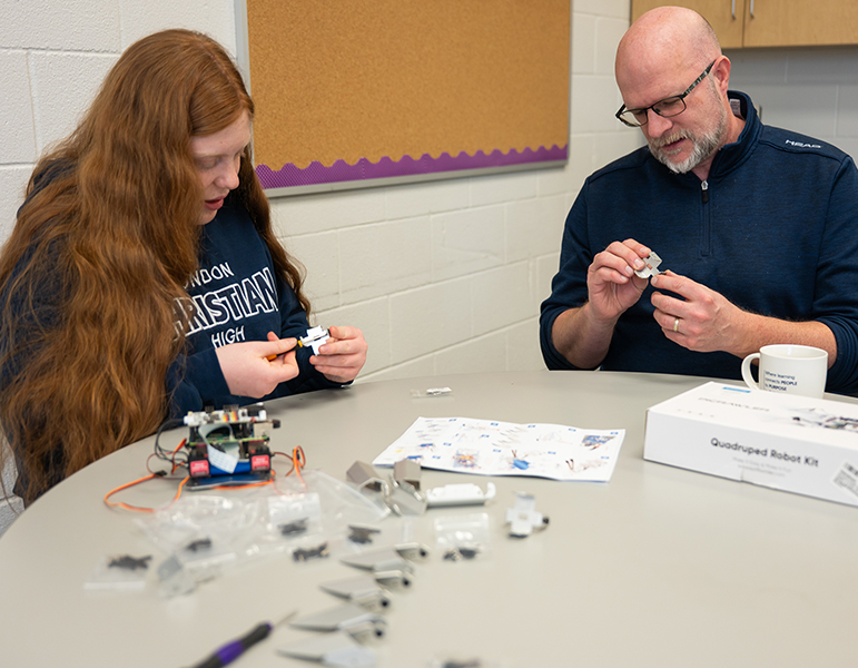 teacher and student working on robotics