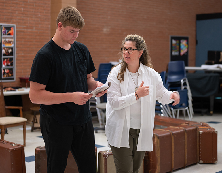 Student and drama teacher reshearsing