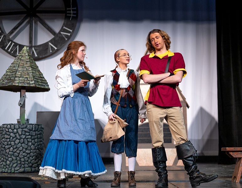 3 student actors performing beauty and the beast as Belle, Gaston and Lefou